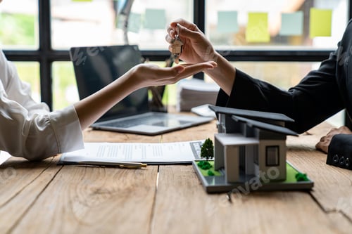 Preview: Cropped image of a real estate agent selling broker holds the keys and the model house is given to t