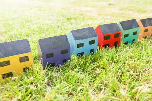 Preview: Row of wooden toy houses on grass