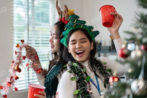 Preview: Smiling Women Celebrating the Christmas Holiday Indoors