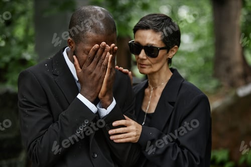 Preview: Crying Black Man and Senior Wife Comforting Husband at Cemetery
