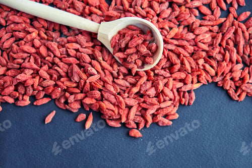 Preview: Goji in bowl on wood table. Top view of fresh goji in scoop and bowl. Goji in heart shape on table.