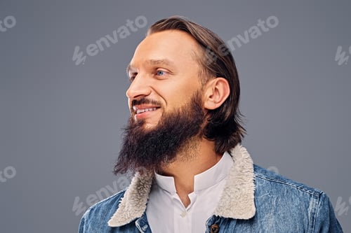 Preview: Bearded male with long hair dressed in a denim jacket.