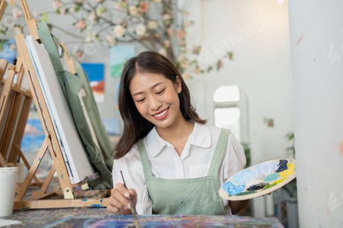 Preview: Asian woman is painting art. She is a professional artist. Watercolor artist is painting art on pape