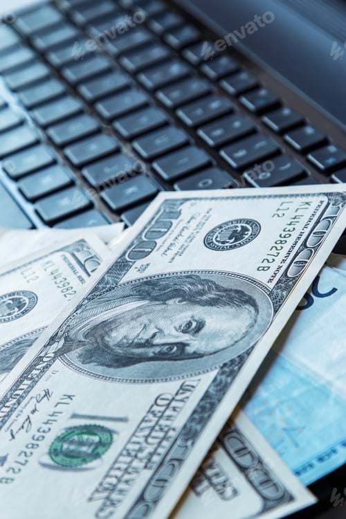 Preview: Banknotes over laptop keyboard