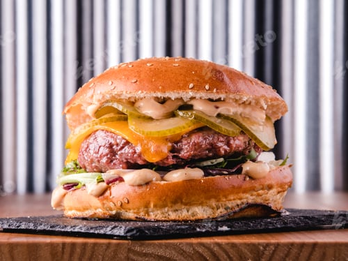 Preview: Close up view of a delicious loaded hamburger ready to eat. Fast and unhealthy concept.