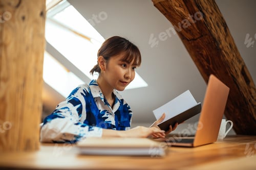 Preview: Japanese woman working at home and taking notes