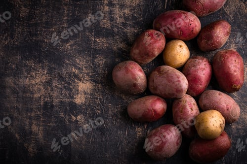 Patatas crudas crudas sobre mesa oscura