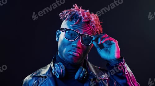 Preview: Futuristic neon lighting. Young african american man in the studio