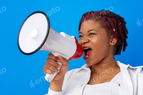 Preview: African american woman using megaphone against blue background