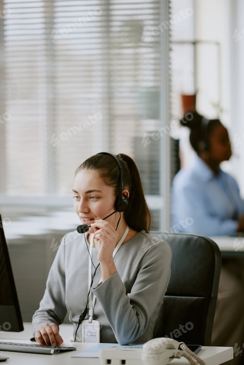 Professional Woman Working at Computer with Headset On