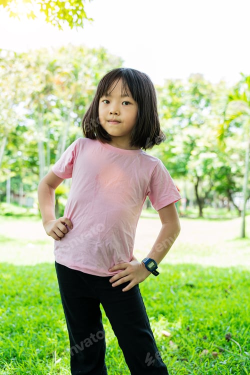 Preview: Portrait of pretty child girl standing in summer park. Happy smiling children outdoor