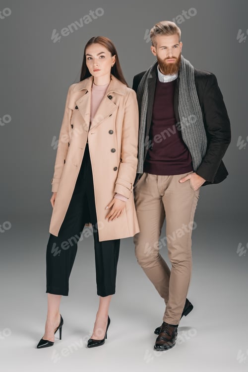 Preview: fashionable young couple in autumn coat and jacket posing isolated on grey