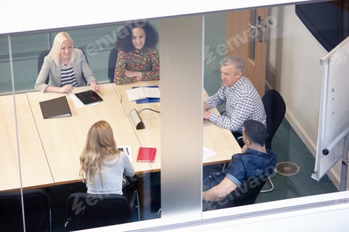 Preview: High angle view of businessmen and women having meeting at conference table