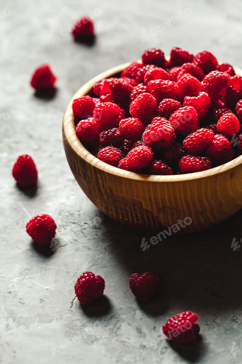 Preview: raspberries in wood bowl on gray table, vintage
