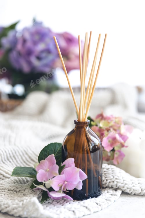 Preview: The aroma diffuser with the stick perfume and flowers on a blurred background.