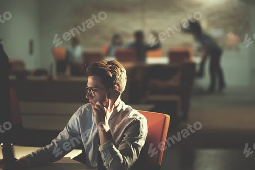 Preview: man using mobile phone in dark office