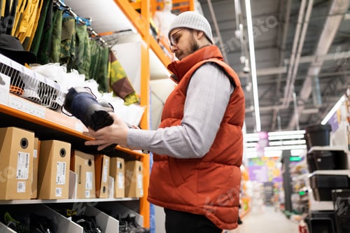 Preview: hardware store customer chooses shoes to work on a construction site with impact protection