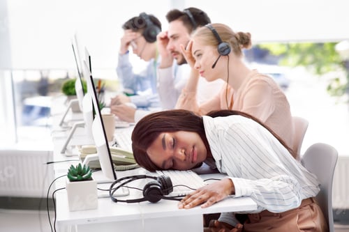 Preview: Tired hotline consultant sleeping at her desk, feeling exhausted or stressed after communication