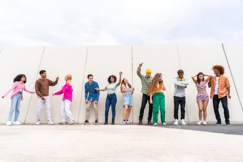 Vista previa: Feliz y juguetón grupo multiétnico de jóvenes amigos que se unen al aire libre