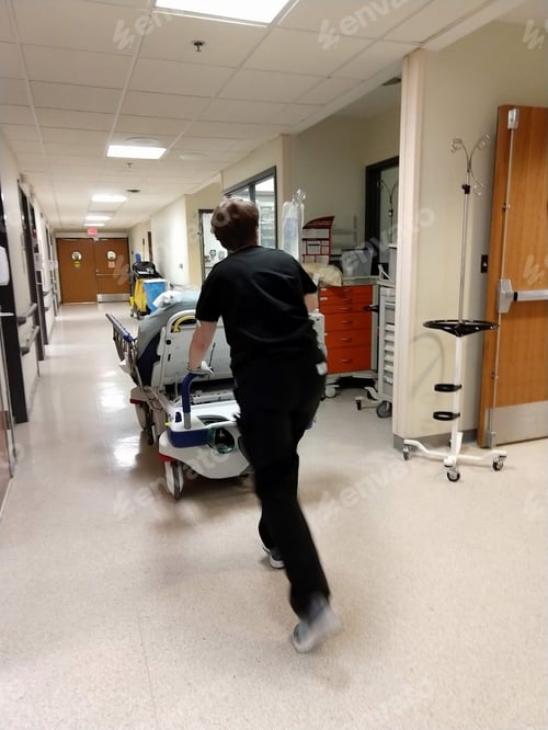Preview: A patient being pushed on a gurney through a hospital ER Emergency Room hallway with an IV