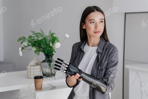 Preview: Purposeful brunette caucasian girl in grey shirt attaching artificial palm to carbon mechanical hand