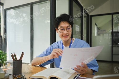 Preview: Smiling male medical student reading books, preparing for university exams in library.