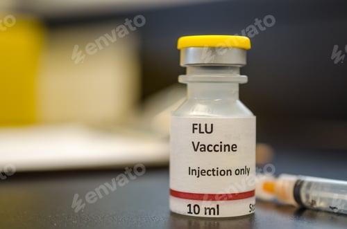Preview: A vial of flu vaccine with a syringe at the background