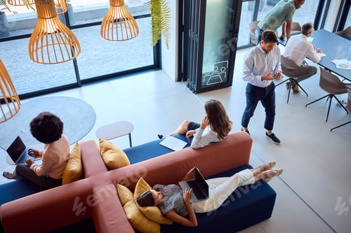 Preview: Overhead View Of Modern Open Plan Office With Staff Working Around Table And Breakout Seating Area