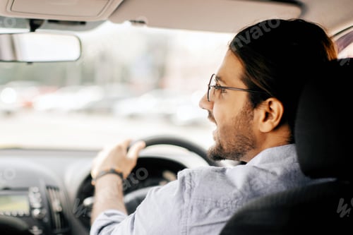 Preview: Back view of middle-eastern guy driving auto