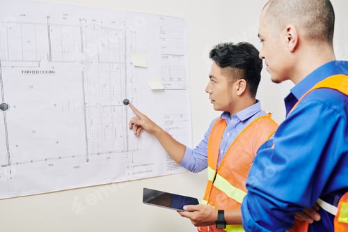 Preview: Team of engineers discussing blueprint