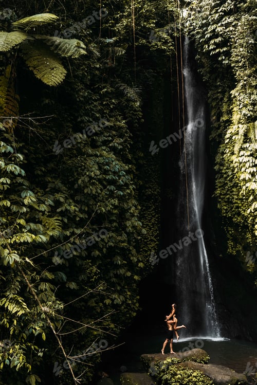 Preview: Happy couple having fun at a waterfall in Bali. A couple having fun at a waterfall in Indonesia
