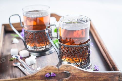 Preview: Tasty hot tea with fresh green leaves on white background