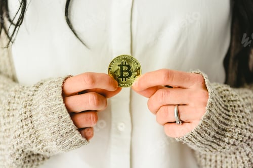 Preview: Woman's hands holding a bitcoin coin.
