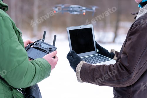 Preview: area planners survey the surroundings with a drone, hands with drone remote controller and a laptop