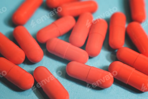 Preview: Close up many orange pills on the blue background.