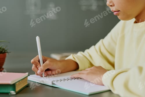 Preview: Asian Child Writing in Notebook during Classroom Learning Activity