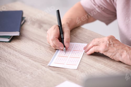 Preview: Senior woman filling out lottery ticket at table, closeup