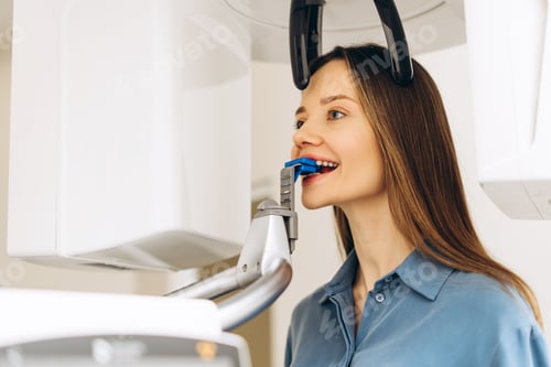 Preview: Young woman in dentist clinic making 3d x ray using radiography equipment