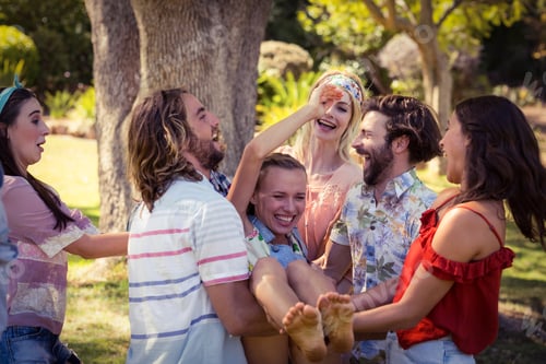 Preview: Group of friends lifting woman at campsite
