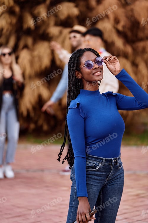 Preview: Woman with sunglasses smiling while having fun at an outdoor party.