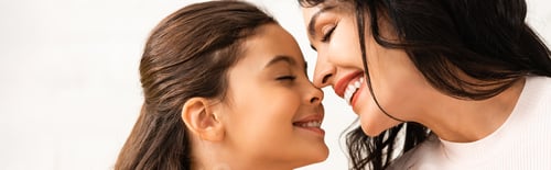 Preview: panoramic shot of happy mom and daughter smiling face to face with closed eyes on mothers day