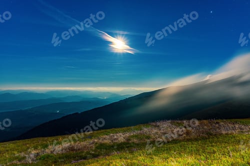 Preview: Thick fog covering mountain hills at bright night