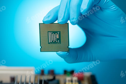 Preview: Electronic engineer hand holding computer chip on blue background. Chipset of electronic circuit