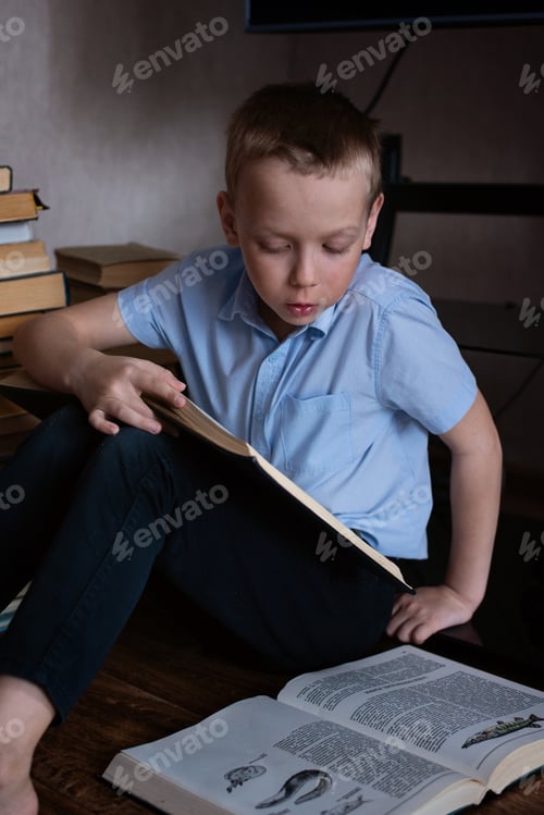 Preview: Young Boy Reads Book While Sitting on Floor