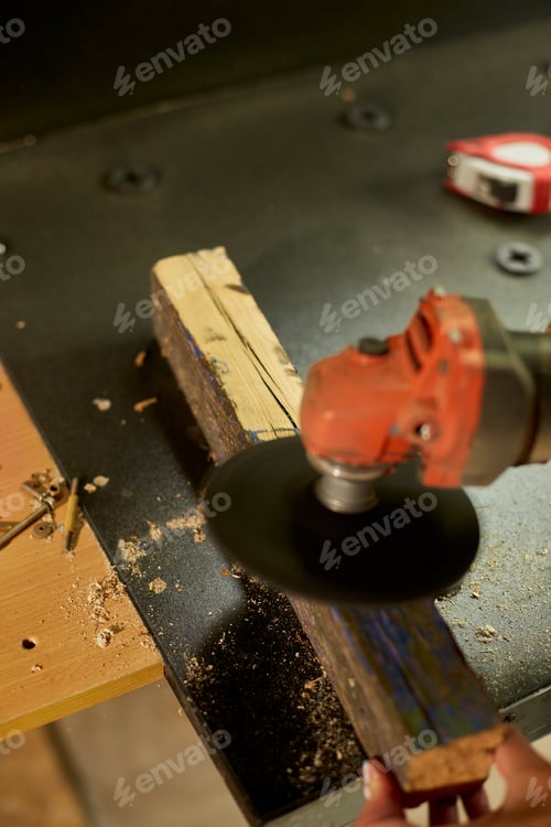 Preview: Close up of a worker woman hand grinds, sanding the wood in workshop