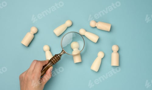 Preview: Wooden men and a magnifying glass on a blue background.