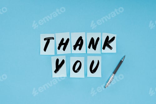 Preview: thank you wording on sticky notes and pen isolated on blue background