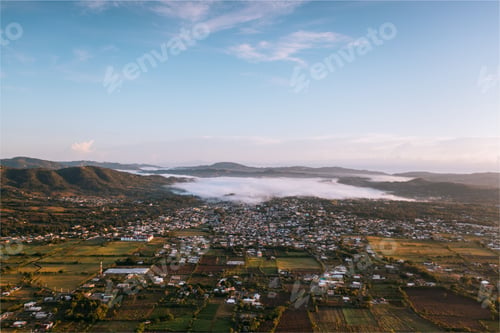 Preview: Aerial view of a town in a misty valley.
