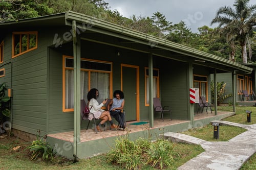 Preview: Black couple sharing smartphone on terrace of countryside house