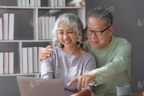 Preview: Happy mature couple using laptop at home.